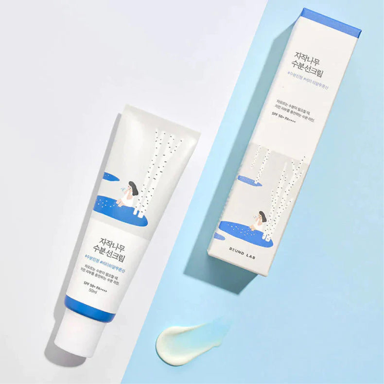 Round Lab Birch Juice Sun Cream tube and box with cream swatch on a light blue background